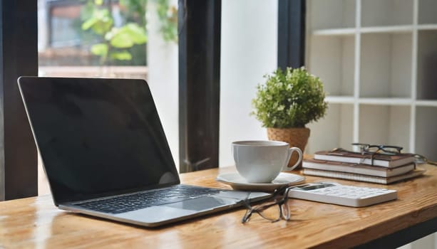 Modern workplace with laptop computer, coffee cup and office supplies