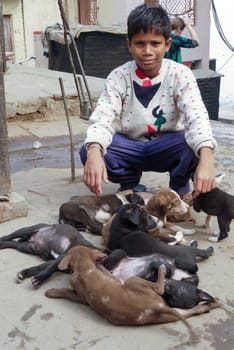 Varanasi, India - December 10, 2009: boy is selling young dogs in Varanasi, India. Dog meat is eaten in India.