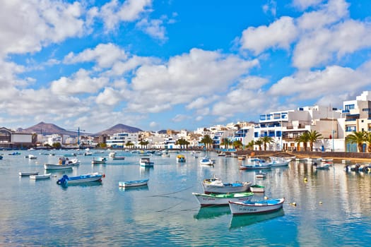 Arrecive, Spain - December 23, 2010: fisherman anchors the boat in Charco de San Gines in Arrecife, Spain. The harbor area was remodelled by Canarian architect César Manrique in 1984.