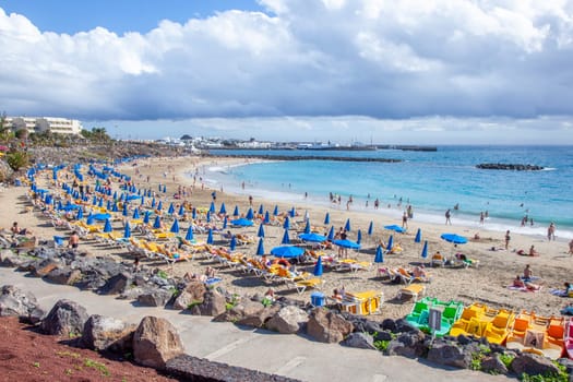 BPlaya Blanca, Spain - December 29, 2010: people enjoy the beach Playa Dorada at the village Playa Blanca in Lanzarote