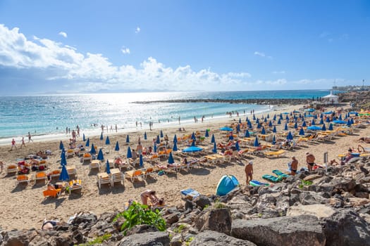 BPlaya Blanca, Spain - December 29, 2010: people enjoy the beach Playa Dorada at the village Playa Blanca in Lanzarote