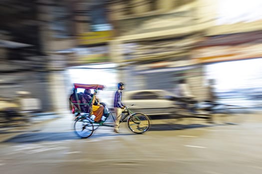 New Delhi, India - November 10, 2011:  rickshaw driving in blurred motion by night in Chandni Chowk. The Chandni Chowk is one of the oldest and busiest markets in Old Delhi, India.