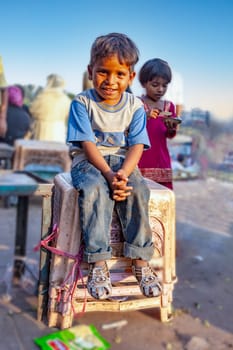 New Delhi, India - November 10, 2011:  young boy sitting on plastic chairs at  the Meena Bazaar Market in Delhi, India. Shah Jahan founded the bazaar in the 17th century.