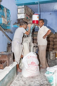 New Delhi, India - November 11, 2011:  bakerman fills flour in the machine to bake bread.