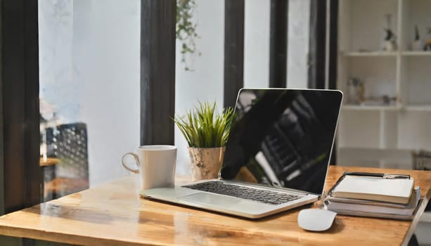 Modern workplace with laptop computer, coffee cup and office supplies