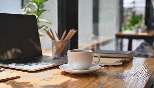Modern workplace with laptop computer, coffee cup and office supplies