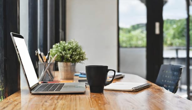 Modern workplace with laptop computer, coffee cup and office supplies