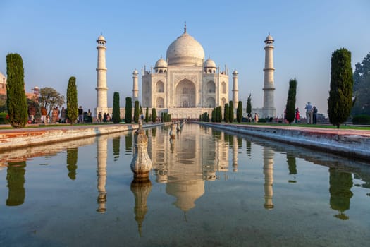 Agra, India - November 15, 2011: people visit Taj Mahal in India with reflection in pond.