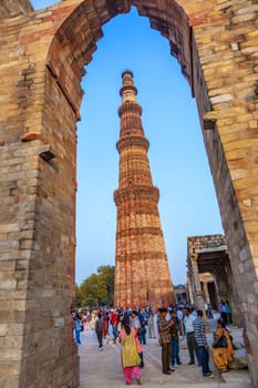 DELHI, INDIA - NOV 13, 2011: people visit Qutb Minar, Delhi, the worlds tallest brick built minaret at 72m, built between 1193 and 1386
