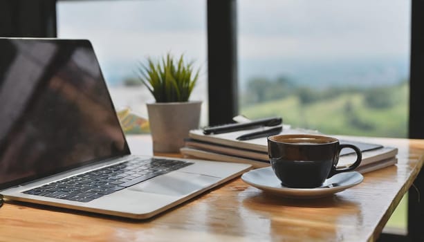 Modern workplace with laptop computer, coffee cup and office supplies