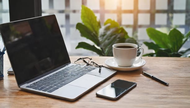 Modern workplace with laptop computer, coffee cup and office supplies