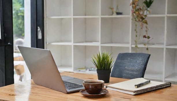 Modern workplace with laptop computer, coffee cup and office supplies