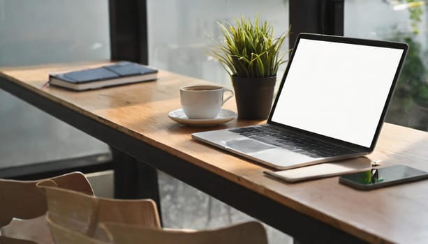 Modern workplace with laptop computer, coffee cup and office supplies
