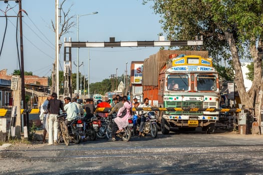 Fathepur Sikri, India - November 16, 2011: people at a train crossing wait for the passing train to continue travel.