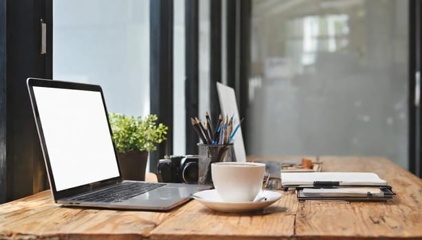 Wood office desk table with a lot of things tablet, laptop ,smartphone ,notepad and coffee cup notepad .copy space virtual interface icons screen.