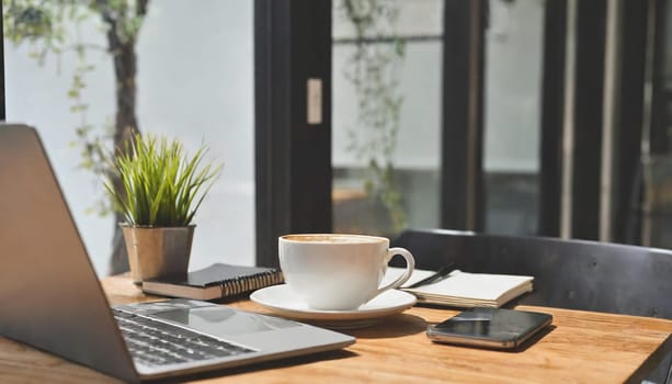 Wood office desk table with a lot of things tablet, laptop ,smartphone ,notepad and coffee cup notepad .copy space virtual interface icons screen.