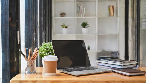 Wood office desk table with a lot of things tablet, laptop ,smartphone ,notepad and coffee cup notepad .copy space virtual interface icons screen.