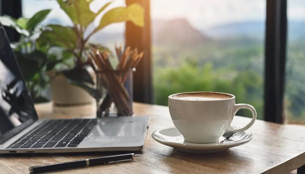 Modern workplace with laptop computer, coffee cup and office supplies