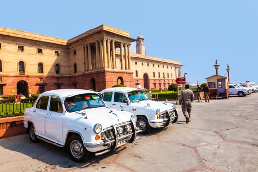 Delhi, India - November 17, 2011: AMBASSADOR car in front of indian parliament. the replica of Morris Oxforf model is still produced by HINDUSTAN MOTORS and standard for politicians.