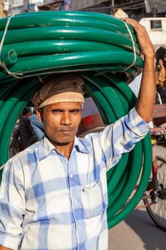 New Delhi, India - November 17, 2011: streetlife at oldest market Chandni Chowk in old Delhi. People carrying goodson their head at Meena Bazaar in Chandni Chowk.