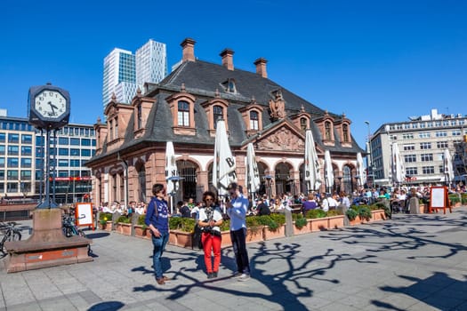 Frankfurt, Germany - March 25, 2012: people like to promenade downtown Frankfurt at the old Hauptwache - engl: main guard - at a summer day.