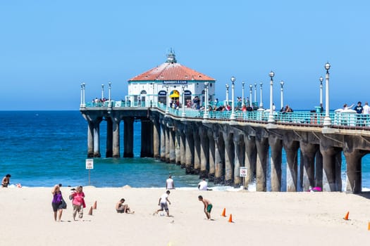 Manhattan Beach, USA - June 24, 2012: people enjoy the beach at the pier in Manhattan Beach, USA.  The famous pier with the octagonal house was completed and dedicated on July 5, 1920.