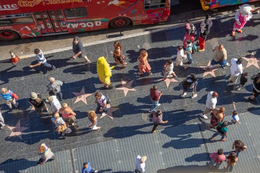 Los Angeles, USA - June 24, 2012: tourists enjoy walking at the walk of fame, the hollywood boulevard,  looking for the foot and handprints and of the stars at the sidewalk.