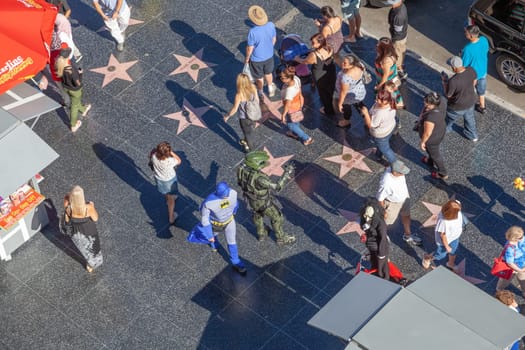 Los Angeles, USA - June 24, 2012: tourists enjoy walking at the walk of fame, the hollywood boulevard,  looking for the foot and handprints and of the stars at the sidewalk.