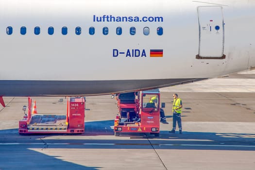 Hamburg, Germany - July 17, 2014: ground operation personal has a short break and talt while loading last baggage to the belly of Lufthansa aircraft.