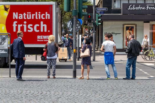 Frankfurt, Germany - June 3, 2014: people waiting at a red traffic light for crossing the street to the Rathenau square in Frankfurt.