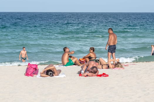 MIAMI, USA - AUGUST 18, 2014: People at the sea side in Miami, USA. Miami Beach is a popular destination among tourists, spiking during the winter time.