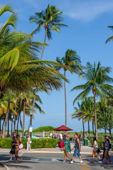 Miami, USA - August 23, 2014: people at south beach walk to ocean drive promenade in late afternoon.