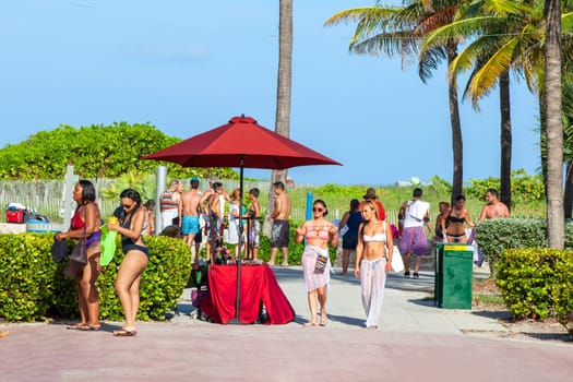 Miami, USA - August 23, 2014: people at south beach walk to ocean drive promenade in late afternoon.