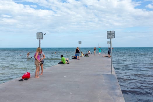 Key West, USA - August 26, 2014: people relax at concrete pier at southernmost point in Key West.