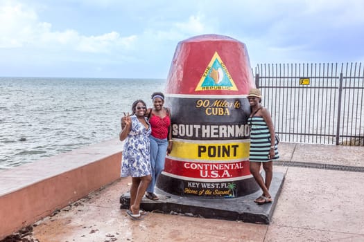 Key West, USA - August 27, 2014: people pose at Southernmost Point marker, Key West, Florida, USA.