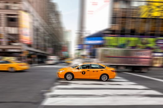 New York, USA - October 21, 2015: taxi in blurred motion at Times Square, featured with Broadway Theaters and huge number of LED signs