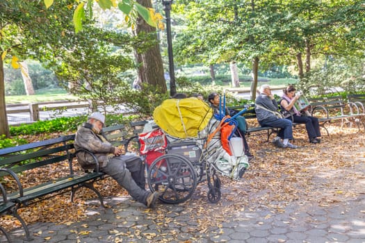 New York, USA - October 21, 2015: homeless man sleeping in central park   in Manhattan, New York, USA. In New York city total number of homeless people in municipal shelters: 52,351.