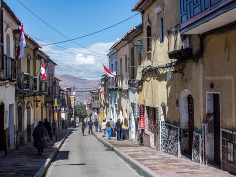 Potosi, Bolivia - November 14, 2015: street scene in the old town of Potosi with houses decorated with bolivian flags.