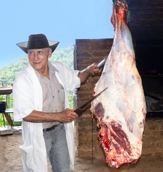 Bogota, Colombia - December 22, 2014: a butcher cuts the meat at the open air market in Bogota, Colombia.