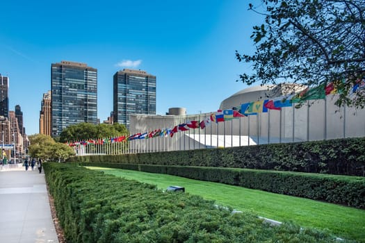 NEW YORK, USA - OCT 4, 2017:   UN Nations building with flags of participating countries in sun.