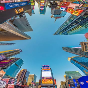 NEW YORK, USA - OCT 4, 2017:  people visit times square with neon advertising of News, brands and theaters   in late afternoon. Times square is a symbol for New York life and amusement.