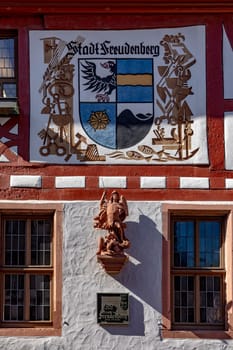 Freudenberg, Germany - April 6, 2018 coat of arms of Stadt Freudenberg - engl: town Freudenberg - with statue of angel as symbol of the town of Freudenberg, Germany.