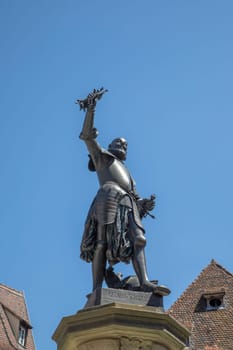 Colmar, France - June 23, 2018:  Closeup detail of a bronze statue of Lazarus von Schwendi, lord of Colmar, by his fountain near medieval timber buildings. Travel and landmarks.