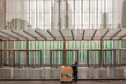 New York, USA - November 5, 2018: entrance doors of one world trade center with man delivering a parcel.