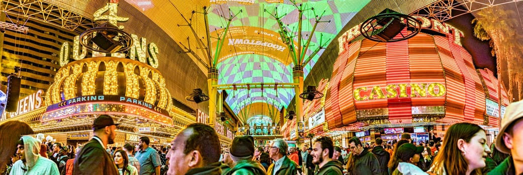 Las Vegas, USA - March 9, 2019: Fremont Street with many neon lights and tourists in downtown Las Vegas. It was the first paved street in Las Vegas in 1925.
