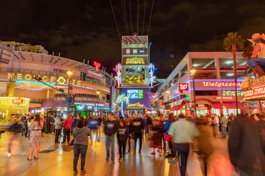 Las Vegas, USA - March 9, 2019: Fremont Street with many neon lights and tourists in downtown Las Vegas. It was the first paved street in Las Vegas in 1925.