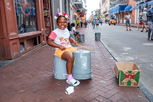 New Orleans  USA - October 24, 2023: young girl plays drums on plastik bins at French Quarter, downtown New Orleans.