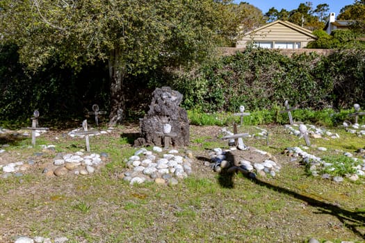Carmel, USA - March 15, 2019: Grave sites of native Americans  - Indians - at the Carmel Mission are marked with stone circles and wooden crosses with abalone shells.
