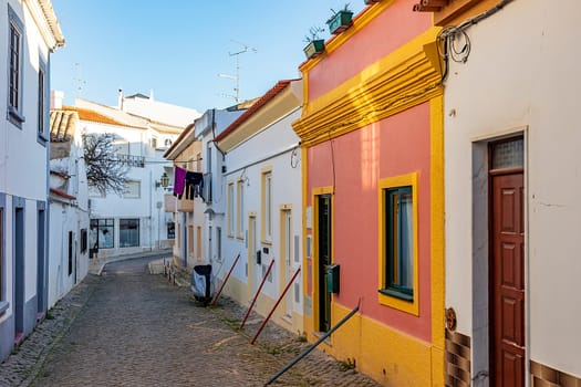 Lagos, Portugal - March 10, 2020: narrow road in old town of Lagos with colorful small historic fishermens houses.