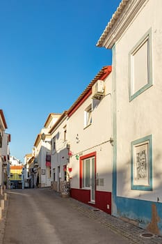 Lagos, Portugal - March 10, 2020: narrow road in old town of Lagos with colorful small historic fishermens houses.